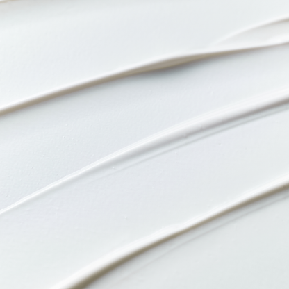 Texture blanche de crème solaire étalée en fines stries