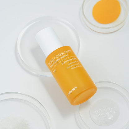 Flacon de sérum orange parmi des coupelles de soin