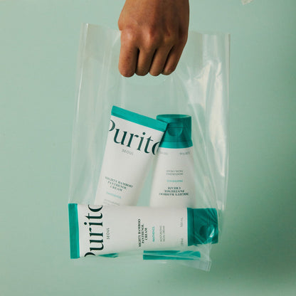 Sac transparent tenu en main contenant des soins de la gamme verte