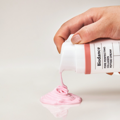 Crème rose distribuée par le flacon-pompe sur une surface claire