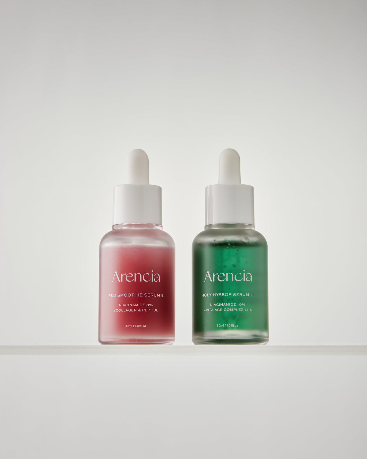 Flacons de sérums rose et vert présentés côte à côte