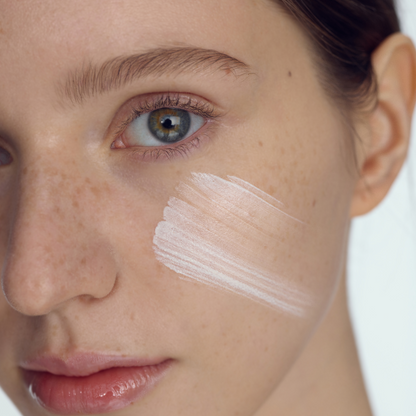 Trace de crème solaire blanche étalée sur la joue